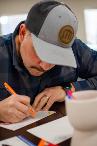 A Geneva Capital employee writing letters of encouragement for kids with cancer and their families.