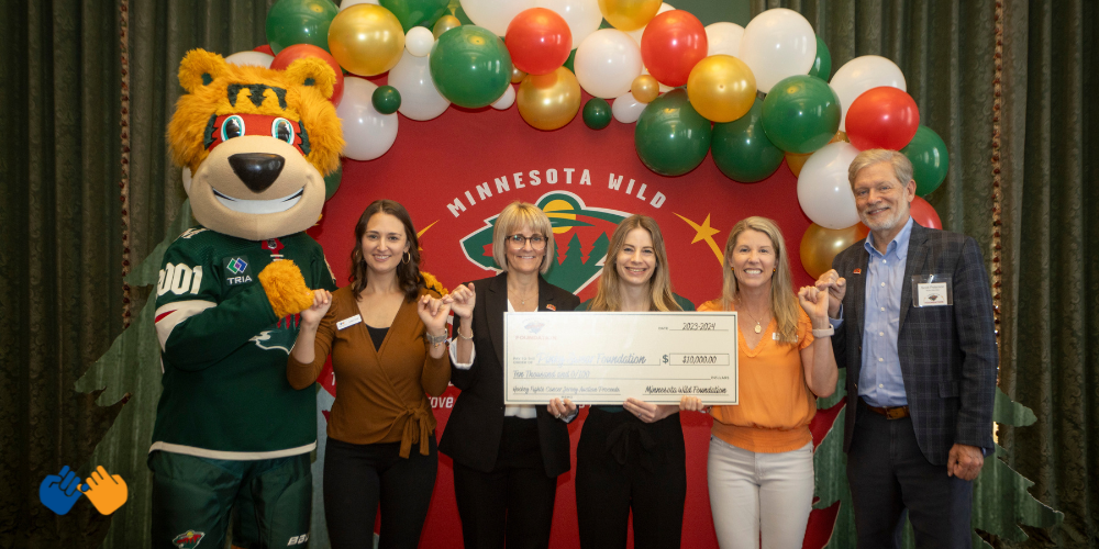 Erica and the Pinky Swear Foundation team accepting a check from the MN Wild Foudation