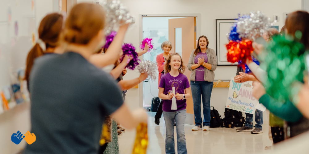 All-Star Anne with her care team surrounding her as she rang her bell indicating the end of her treatment