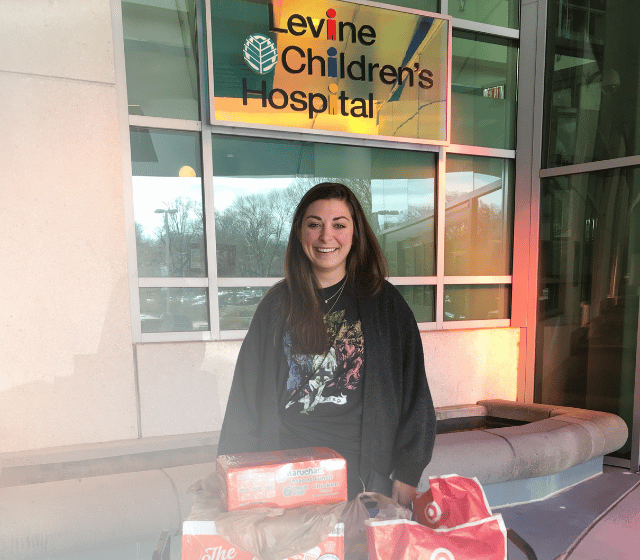 A Pinky Swear Volunteer with a cart of food to give to the Levine Children's Hospital Pinky Swear Pantry