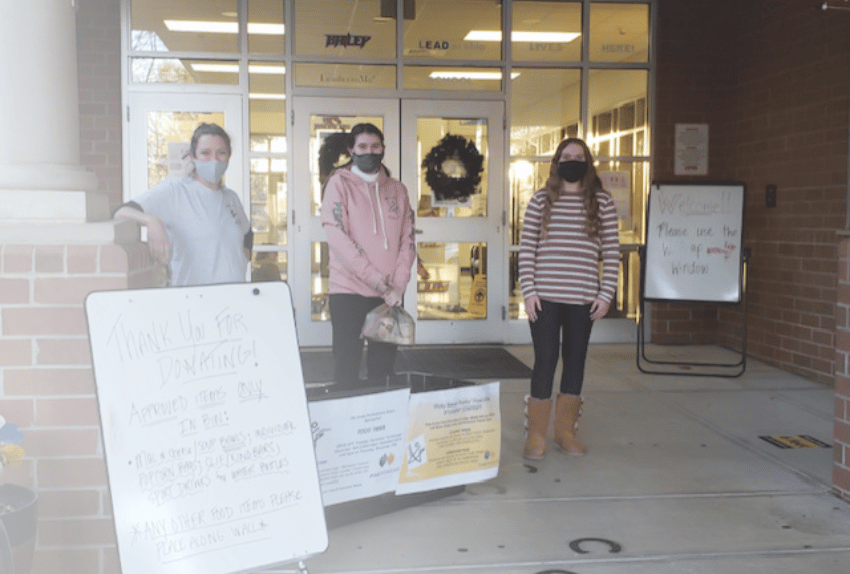 Three volunteers wearing masks standing outside collecting donations for Pinky Swear Foundation